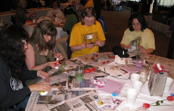 Ladies around a table covered with newpaper and supplies
